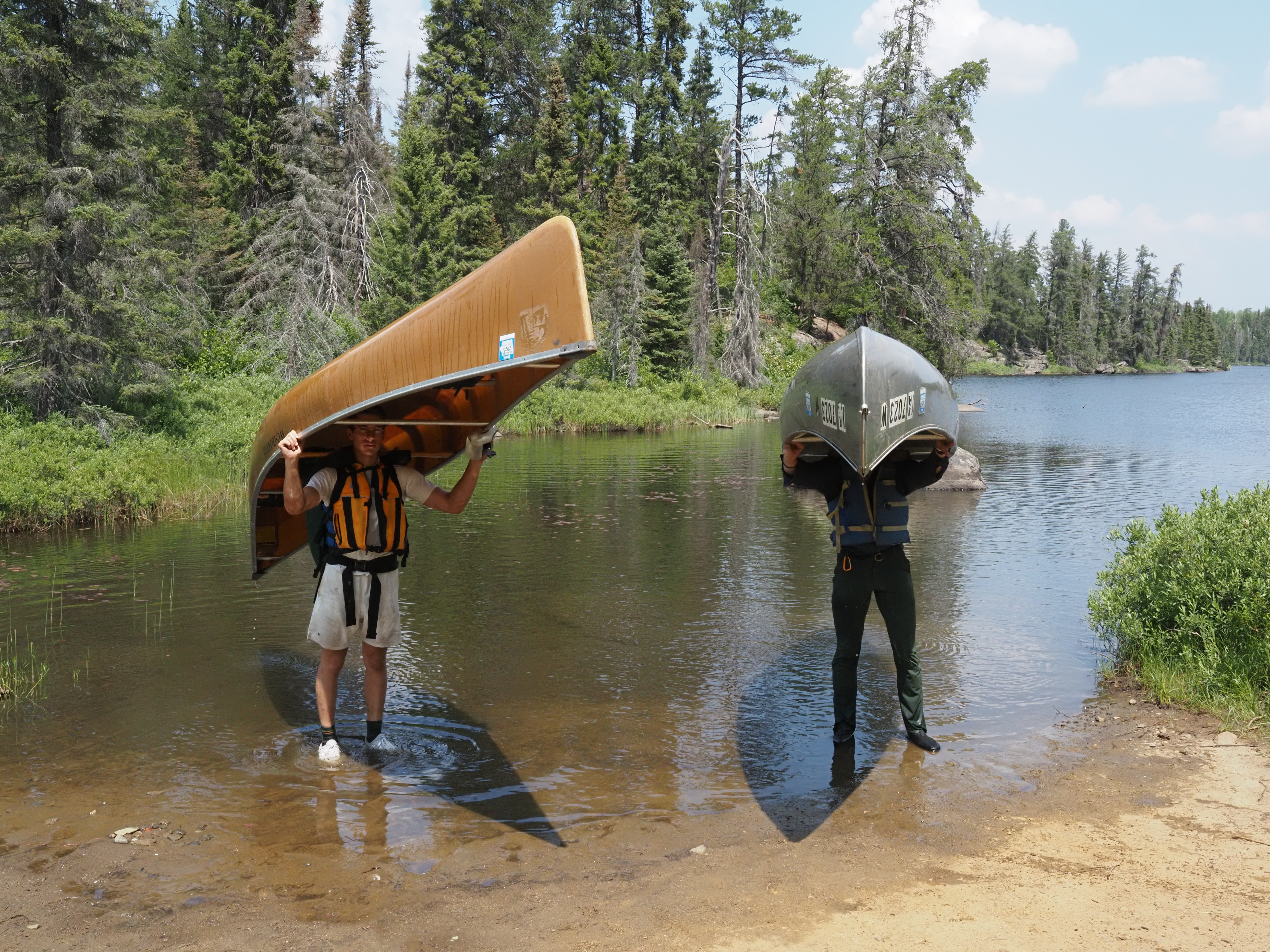 Two men carrying a canoe