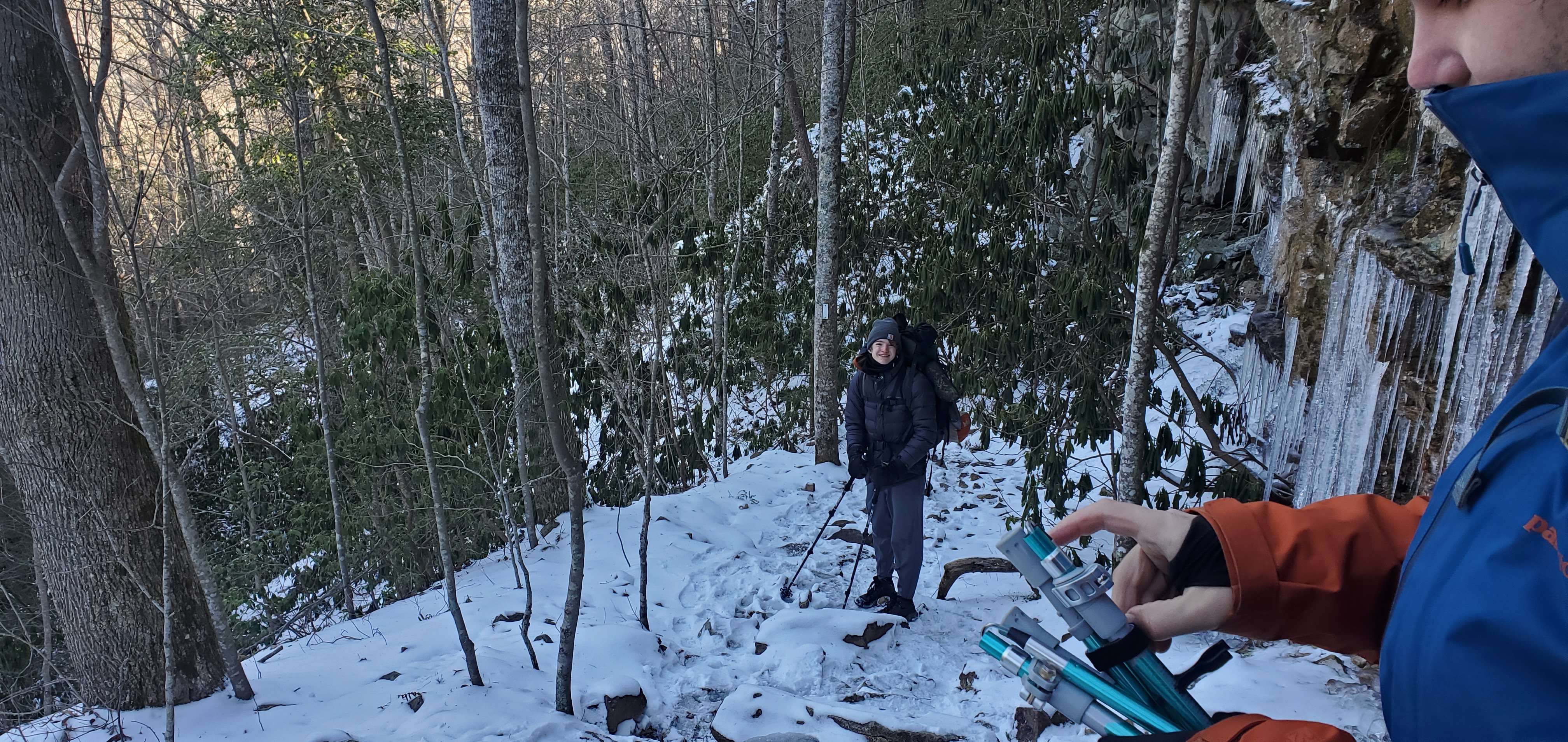 A man standing on a snowy trail